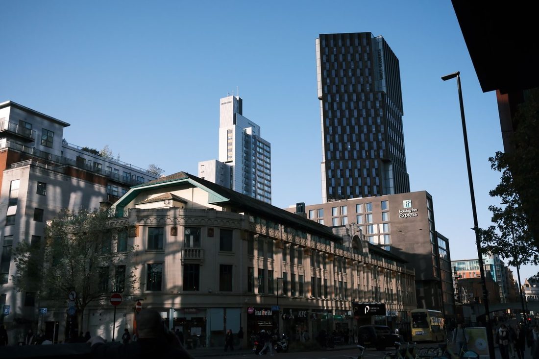 A vibrant urban scene featuring modern high-rise buildings under a clear blue sky.