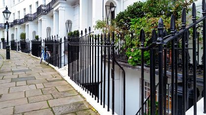 Stunning Georgian townhouses with classic ironwork in Kensington, London. Captured outdoors during the day.