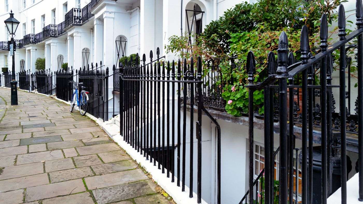 Stunning Georgian townhouses with classic ironwork in Kensington, London. Captured outdoors during the day.