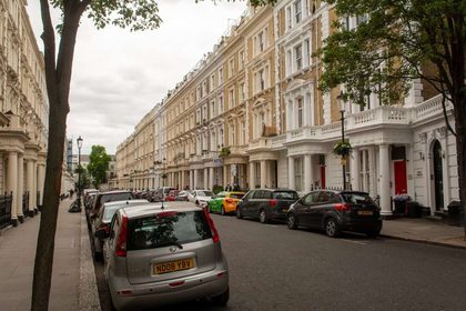 Captivating view of a classic London street with historic row houses and parked cars.