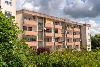 Sunny view of an apartment building surrounded by greenery in Garešnica, Croatia.