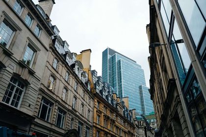 Street view of modern skyscraper juxtaposed with classic architecture.
