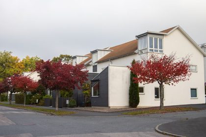 Charming suburban street in Jönköping, Sweden, showcasing vibrant autumn foliage and modern architecture.