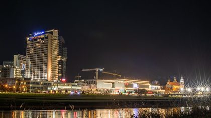 Stunning night view of Vilnius, Lithuania, showcasing city lights and modern architecture along the Neris River.