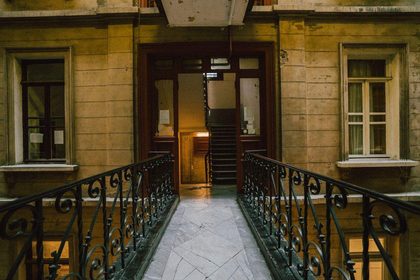 Old building interior featuring a narrow footbridge leading to a doorway, showcasing vintage architecture and design.