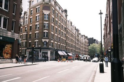 Vibrant street view in central London with classic architecture and bustling activity.