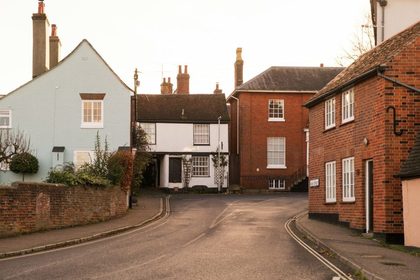 A street with houses and a truck parked on the side of the road