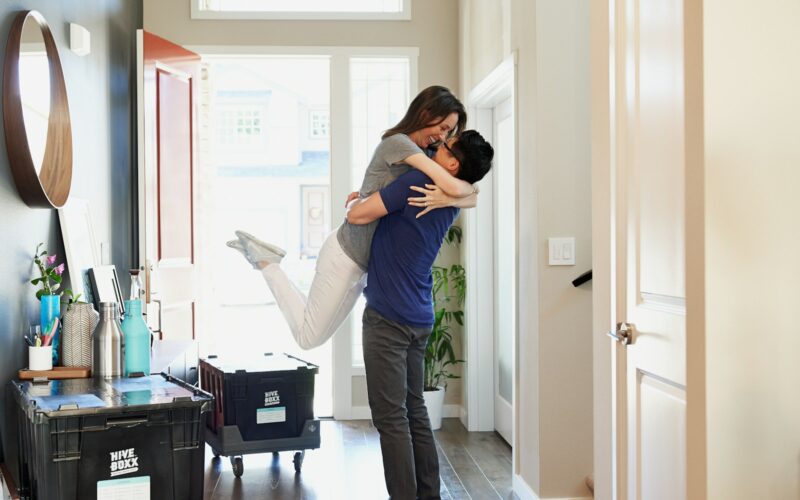 woman in gray long sleeve shirt and gray pants standing beside white wooden door