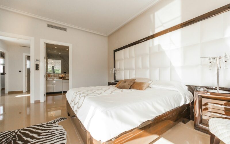 brown wooden bed frame with white cover beside brown wooden nightstand