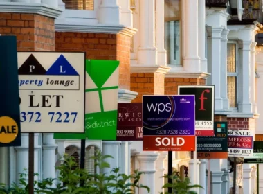 Row of houses with for sale signs.